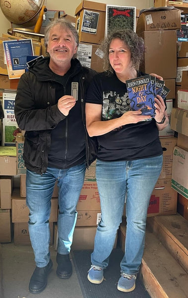 photo of John Connolly with bookmark standing next to bookseller Michelle Souliere