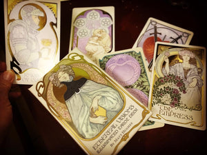 a box of Tarot cards sits on top of some scattered cards